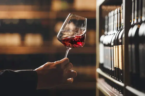Catador evaluando los sulfitos en vino en una copa de este