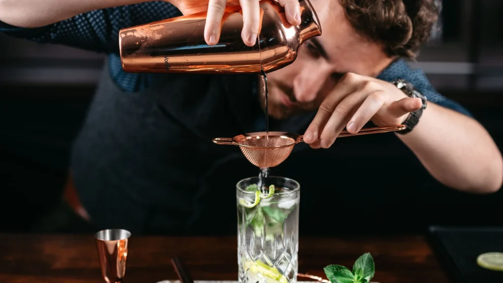 Bartender preparando un cóctel en barra de coctelería contemporánea